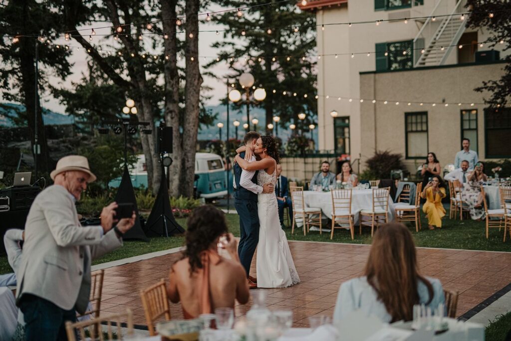 Columbia Gorge Hotel and Spa wedding in Hood River Oregon — historic venue with waterfall views, manicured gardens, and elegant on-site lodging. Mother and grooms first dance during reception.