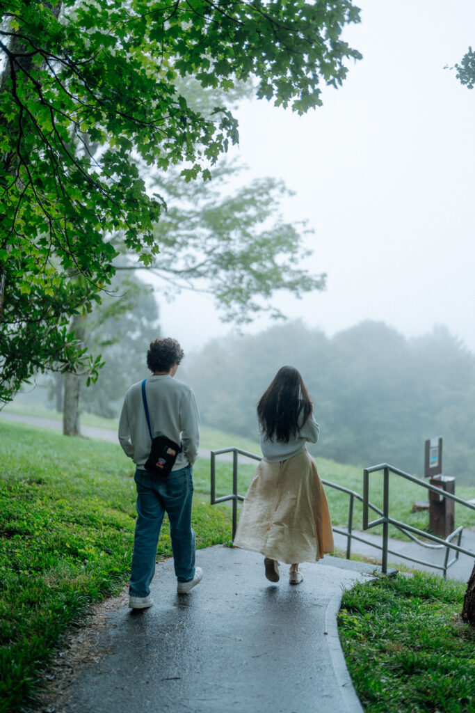 Moody North Carolina engagement photos captured at the couple’s proposal spot in the Smoky Mountains, surrounded by fog and soft overcast light. Romantic and cinematic portraits by destination wedding and engagement photographer KNCAPTURES. Moses Cone