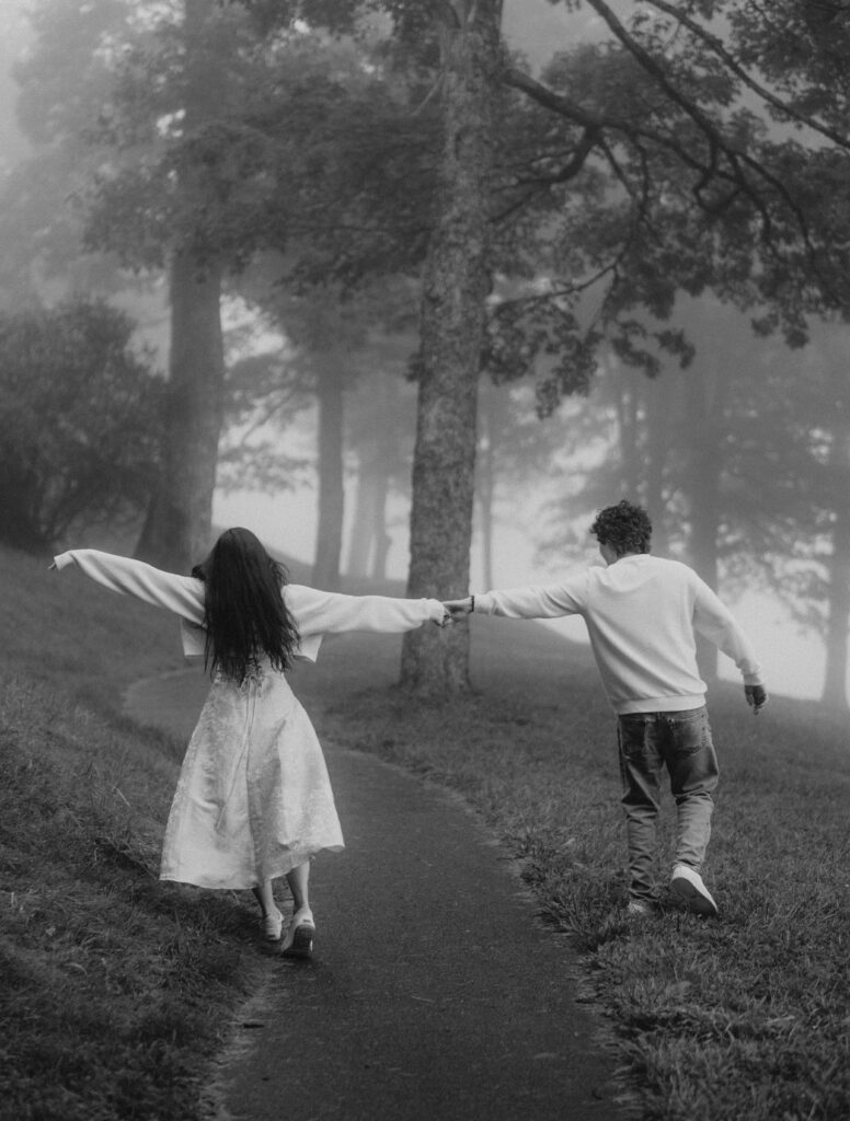 Moody North Carolina engagement photos captured at the couple’s proposal spot in the Smoky Mountains, surrounded by fog and soft overcast light. Romantic and cinematic portraits by destination wedding and engagement photographer KNCAPTURES. Moses Cone
