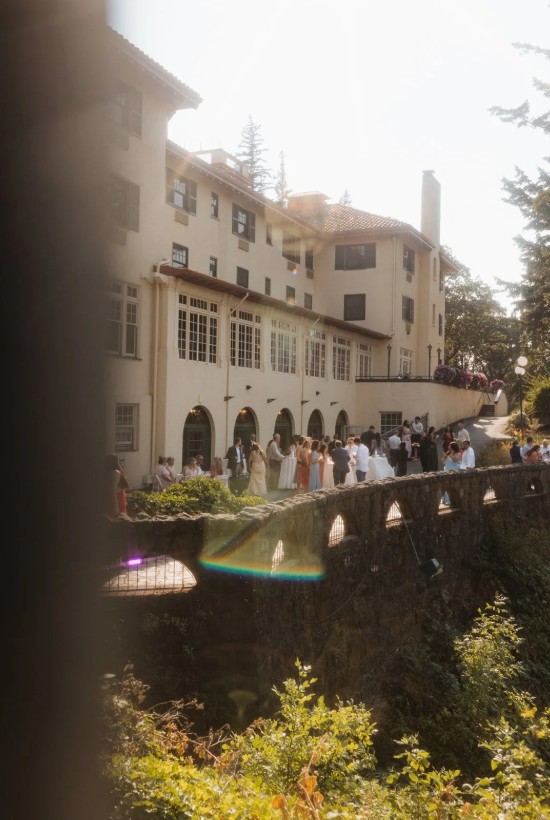 Columbia Gorge Hotel and Spa wedding in Hood River Oregon — historic venue with waterfall views, manicured gardens, and elegant on-site lodging. Guests mingling outside of the event space.