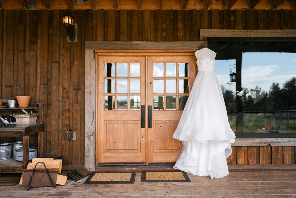 detail photo of wedding dress hanging over doorway ranch wedding in bend oregon 