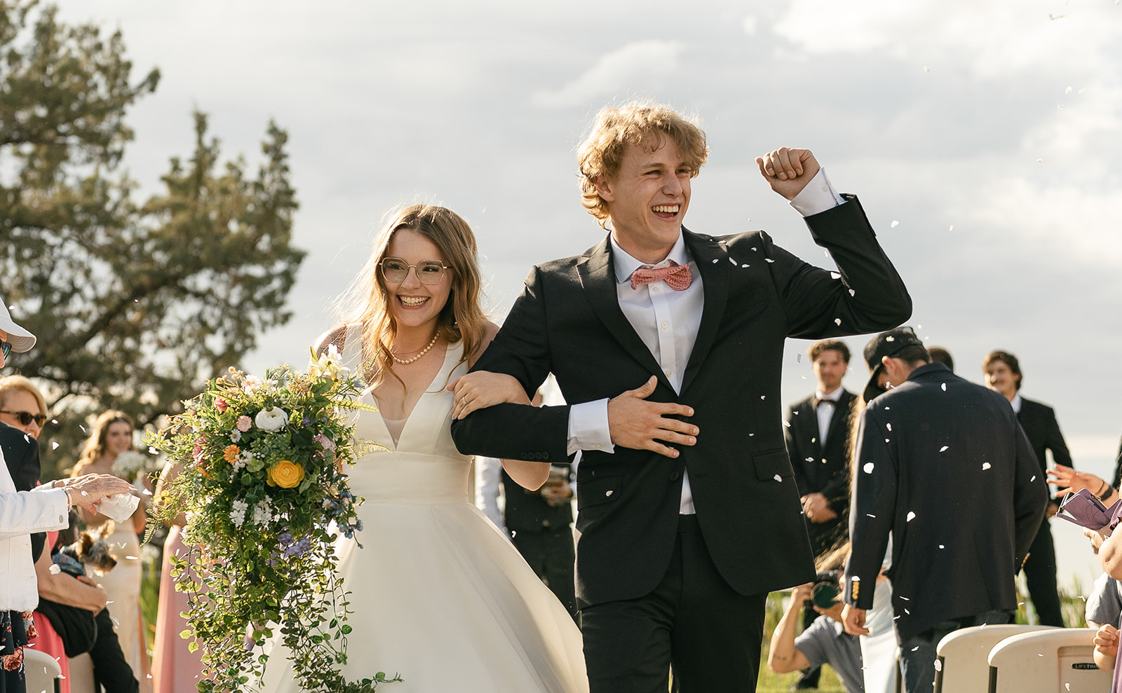 bride and groom walking down aisle with confetti being thrown over them