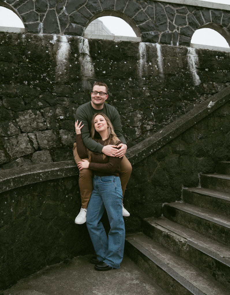 Couple embracing at Crown Point Vista House overlooking the Columbia River Gorge in Oregon