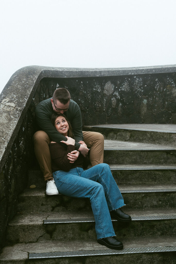 Couple embracing at Crown Point Vista House overlooking the Columbia River Gorge in Oregon