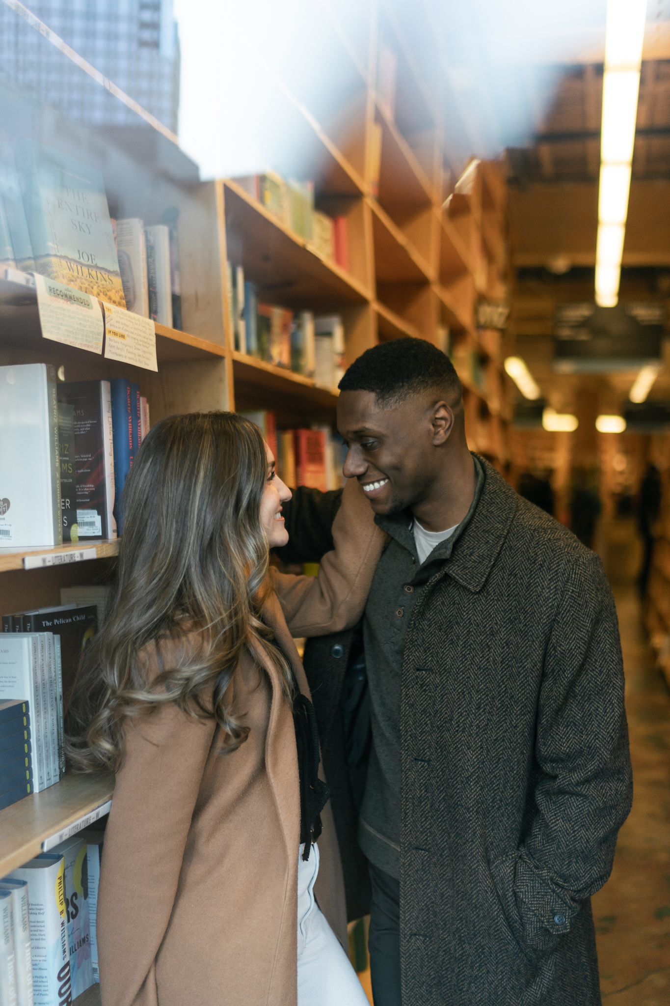 Couple photos inside Powell’s City of Books in Portland, Oregon during a romantic engagement session surrounded by bookshelves.
